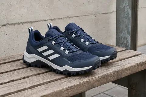Chaussures Adidas Terrex Rockadia bleu encre et blanc posées sur un banc en bois, semelles visibles.