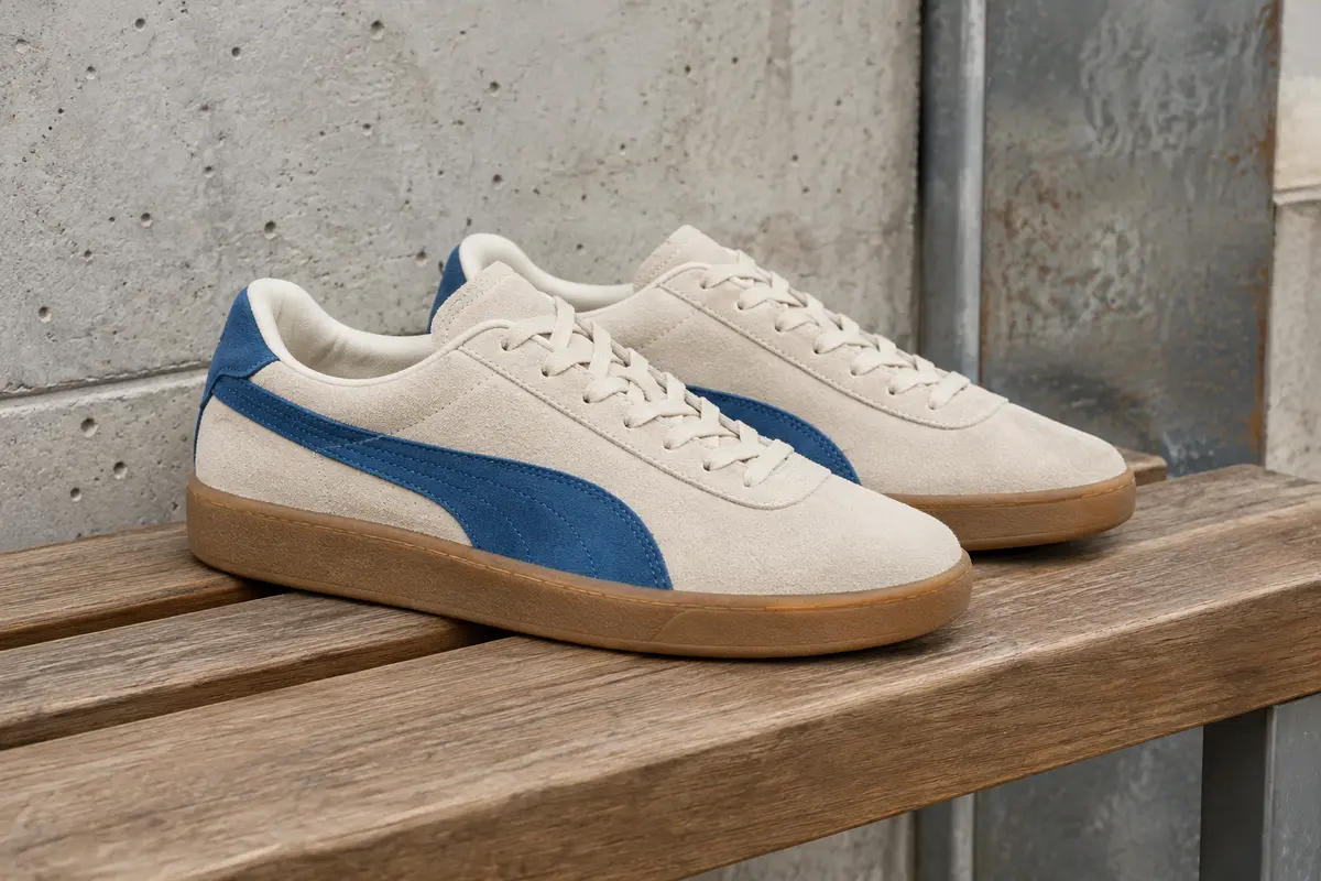 Baskets basses Puma Club II Era en daim jasmin et bleu persan posées sur un banc en bois